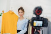 Une jeune femme se filme avec un pull jaune pour les fans sur Instagram