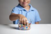 Un garçon prend des smarties dans un bocal