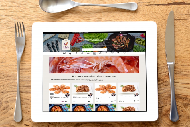 Une tablette présentée comme une assiette avec les couverts. En fond, une appli de livraison de produits frais.. 