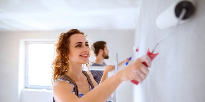 homme et femme repeignant un mur en blanc