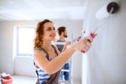 homme et femme repeignant un mur en blanc