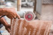 bricoleur découpant une dalle de carrelage à la meuleuse
