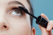 Une femme passe une brosse de mascara sur ses cils