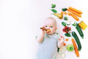 bébé avec des légumes et un pot de compote