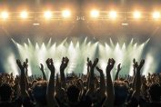 Des mains levées devant une scène de spectacle