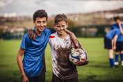 deux garçons couverts de boue sur un terrain de football