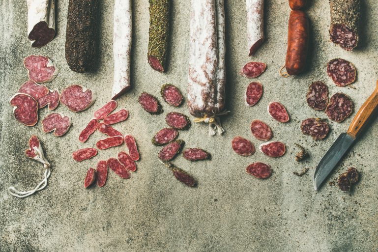 Huit types de saucissons tranchés sont alignés