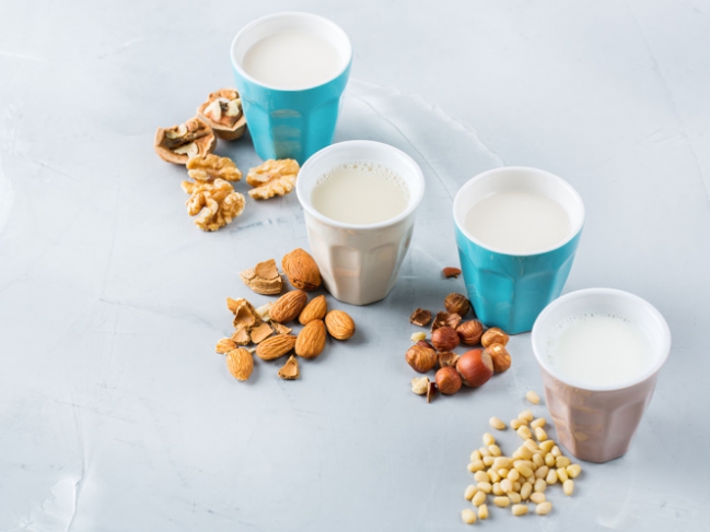 Quatre verres de laits végétaux : noix, amandes, noisettes, soja