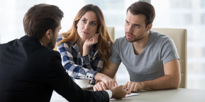 discussion animée entre banquier et couple de clients