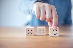 Trois dés avec les logos sourire, tristesse, neutre.