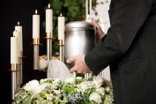 Homme portant une urne, arrière-plan de bougies