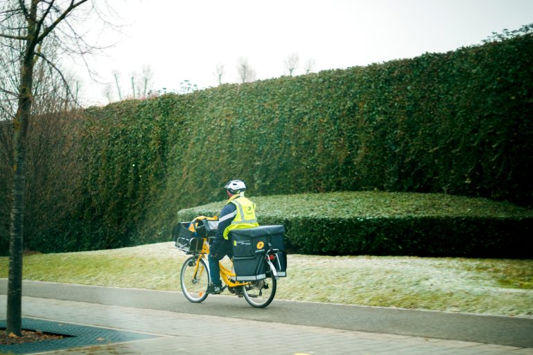 un facteur de La Poste distribuant le courrier à vélo