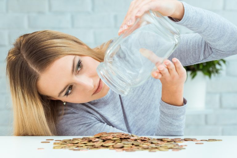 consommatrice vidant un pot rempli de pièces de monnaie