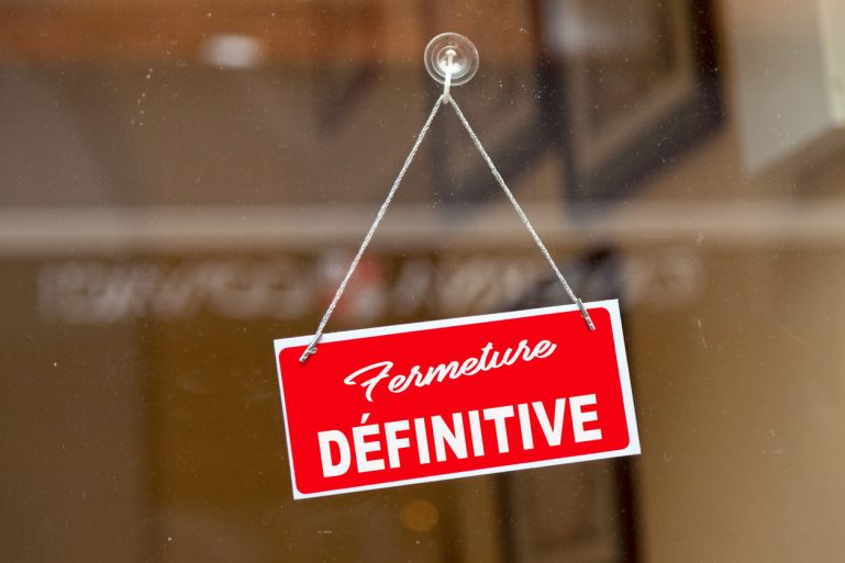 pancarte “fermeture définitive” sur la porte d’un magasin
