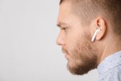 jeune homme avec des écouteurs True Wireless ressemblant à des AirPods