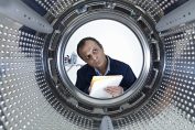 Un homme prend des notes devant le tambour dun lave-linge