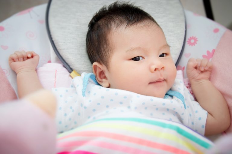 Un bébé avec sa tête posée sur un coussin de tête