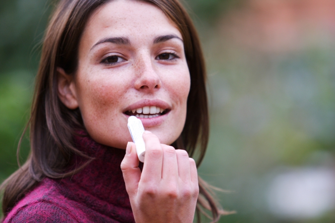 Femme s’appliquant du baume pour les lèvres