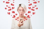 amoureuse tenant un smartphone entouré de jolis cœurs