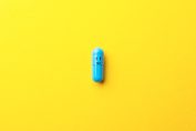 Un comprimé bleu avec un sourire sur un fond jaune