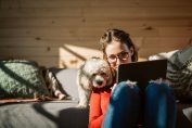 jeune femme et chien devant un écran d’ordinateur