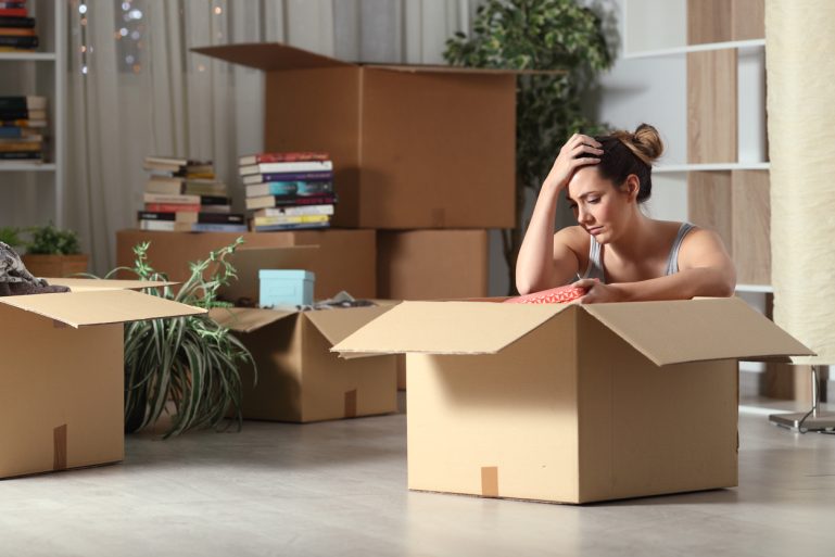 Une femme près d’un carton de déménagement