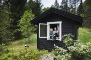 Deux enfants à la fenêtre d’un chalet dans la montagne en été