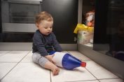 bébé jouant avec des produits ménagers
