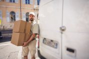 Un livreur près de sa camionnette avec deux colis