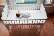 Un bébé dort sur le dos dans son lit