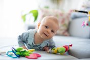 un bébé en éveil sur le ventre avec des jouets