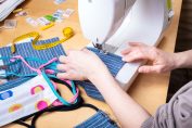Femme utilisant une machine à coudre pour réaliser un masque pendant la pandémie de coronavirus