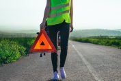 Femme en panne au bord d'une route