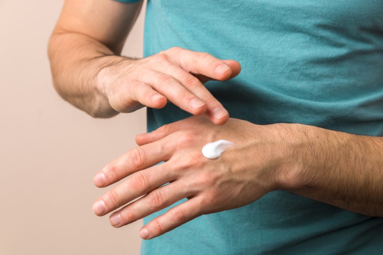 Un homme se mettant de la crème sur les mains