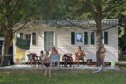 famille devant son mobile home dans un camping en été