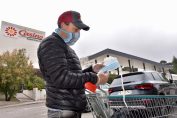 homme tenant des masques jetables sur le parking d’un supermarché à Marseille