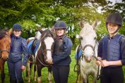 Trois jeunes cavalières avec leurs chevaux