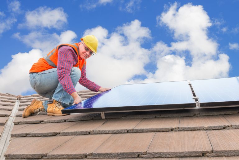 installateur de panneaux photovoltaïques sur un toit