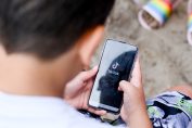 adolescent à la plage avec TikTok sur son smartphone