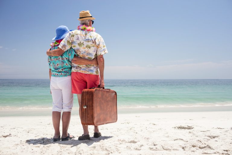 couple avec une valise en bord de mer