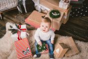 bébé au pied du sapin de Noël avec un cadeau risqué