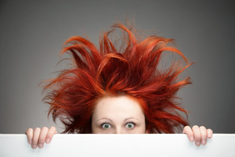 Une jeune femme avec des cheveux roux longs et en pétard
