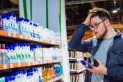 consommateur perplexe devant un rayon de shampoings