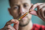 homme tenant une ampoule de vitamine D
