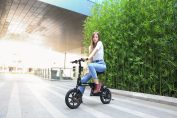 Une jeune femme sur une draisienne électrique Moovway