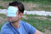 homme avec un masque chirurgical sur les yeux