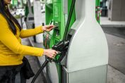 Une femme met sa carte bancaire dans un distributeur automatique de carburant