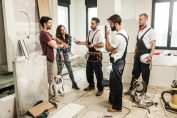 Un couple en discussion avec trois ouvriers sur un chantier de maison