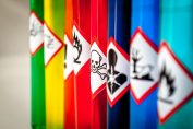 Une rangée de flacons de produits multicolores affichant des logos de sécurité