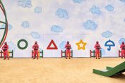 Une image de la série Squid Game avec des personnages armés